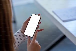 Mock up. image of woman holding mobile phone with blank white screen.