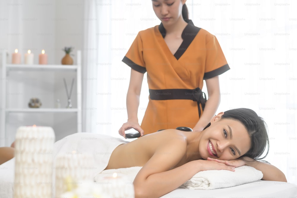 A young asian beautiful woman relaxing and enjoying massage, spa and beauty treatment concept