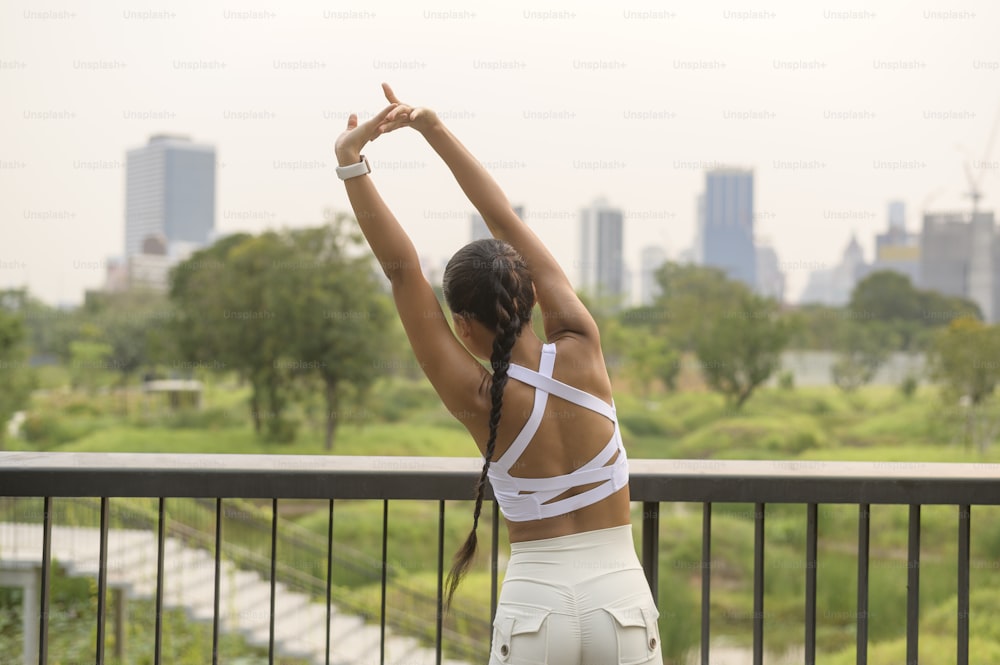 Una joven mujer fitness en ropa deportiva haciendo ejercicio en el parque de la ciudad, Healthy and Lifestyles.