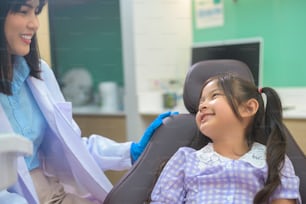 Uma menina fofa com dentes examinados pelo dentista em clínica odontológica, check-up de dentes e conceito de dentes saudáveis