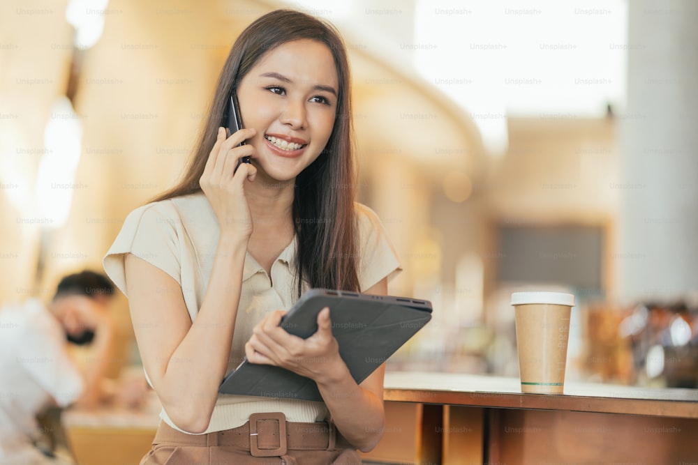smart attractive asian female woman casual cloth freelance work leisure relax working with laptop and smartphone at cafe restaurant urban lifestyle digital nomad working in co working space