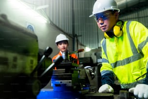 engineer cooperation Two asian maintenance engineers men and women inspect relay protection system with tablet device to control quality control process work a heavy industry manufacturing factory