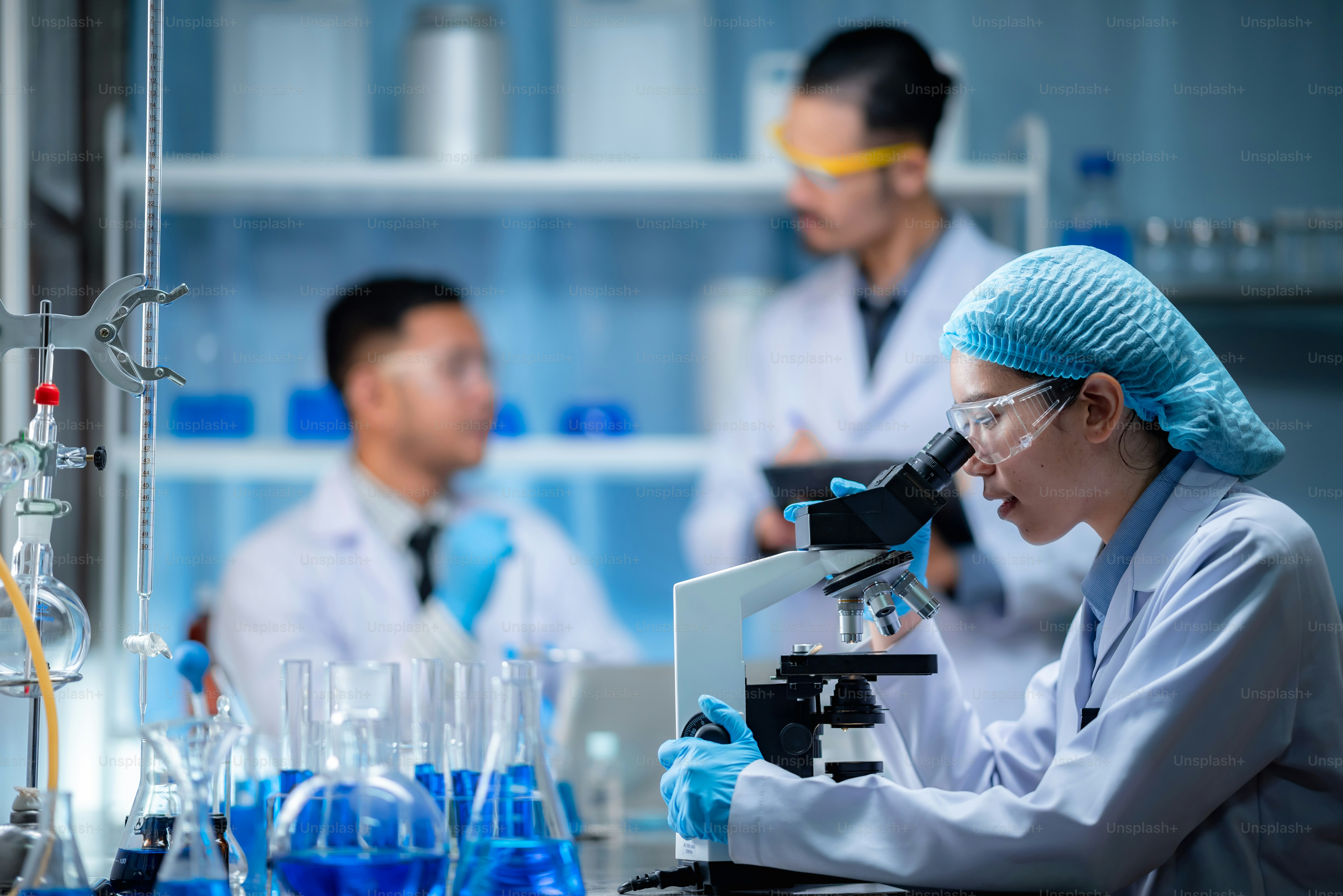実験室で顕微鏡を覗く若い科学者。研究をしている若い科学者。