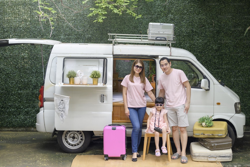 a joyful Asian family enjoying road trip and journey is going on holiday, travel and tourism concept