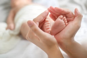 Close of hand holding new born baby's feet