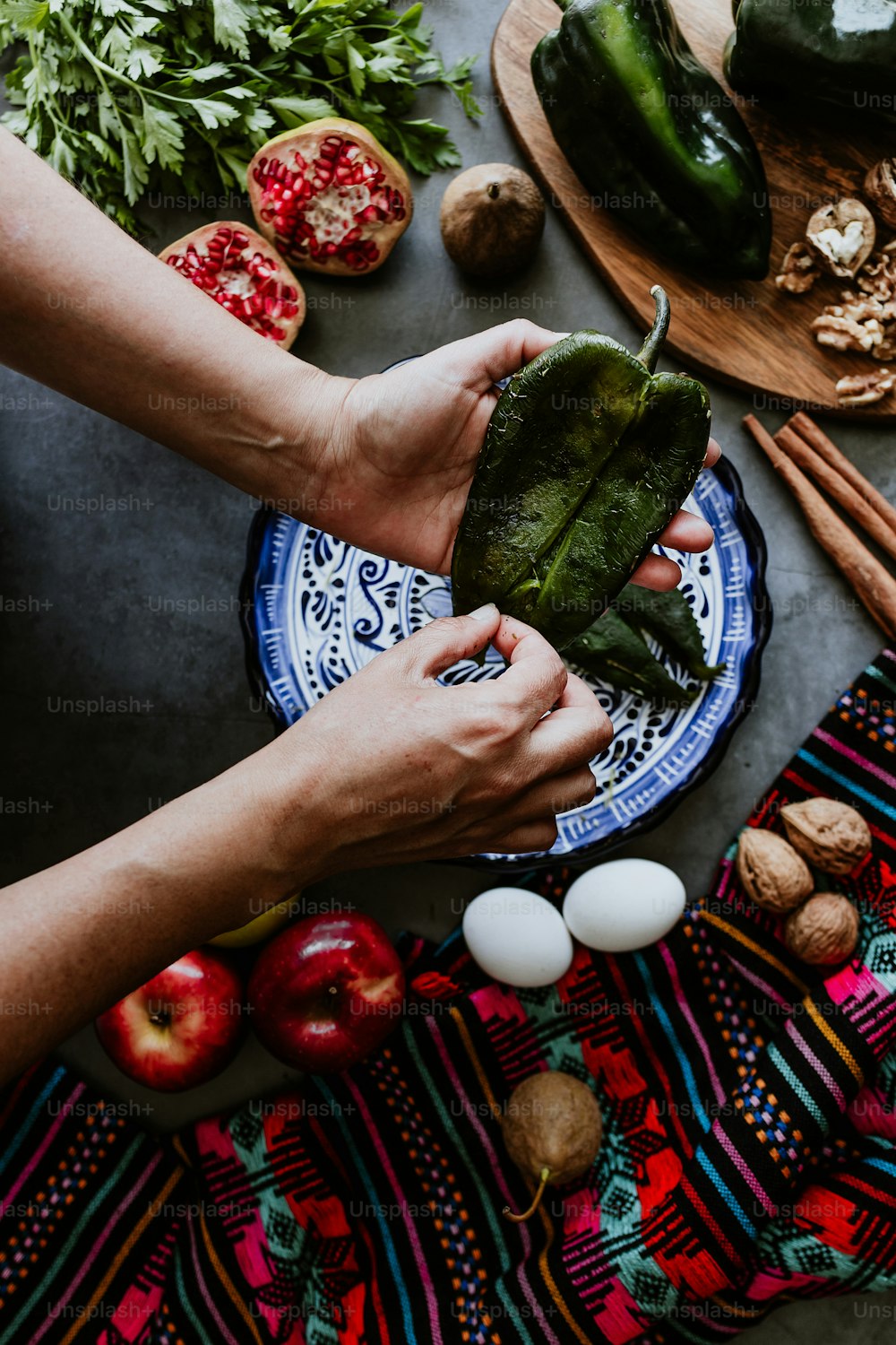 Mujer mexicana cocinando chiles en nogada receta con chile poblano e ingredientes, platillo tradicional en Puebla México
