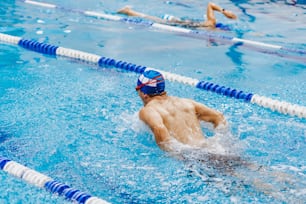 atleta de natación joven hispano con gorra en un entrenamiento de natación en la piscina en México América Latina