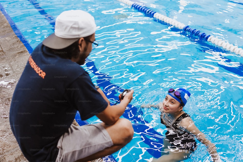 Latin swimming man trainer talking some advices to teenagers swimmers students at the pool in Mexico Latin America