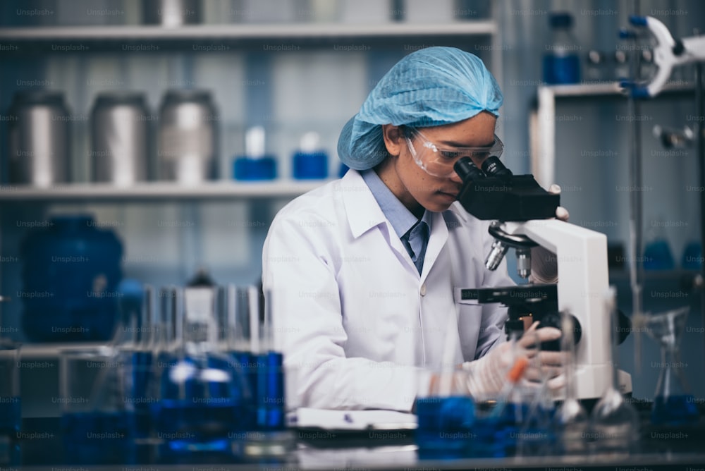 Young scientist working with a microscope in a laboratory. Young scientist doing some research.