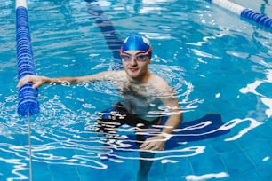 atleta de natación joven hispano con gorra en un entrenamiento de natación en la piscina en México América Latina