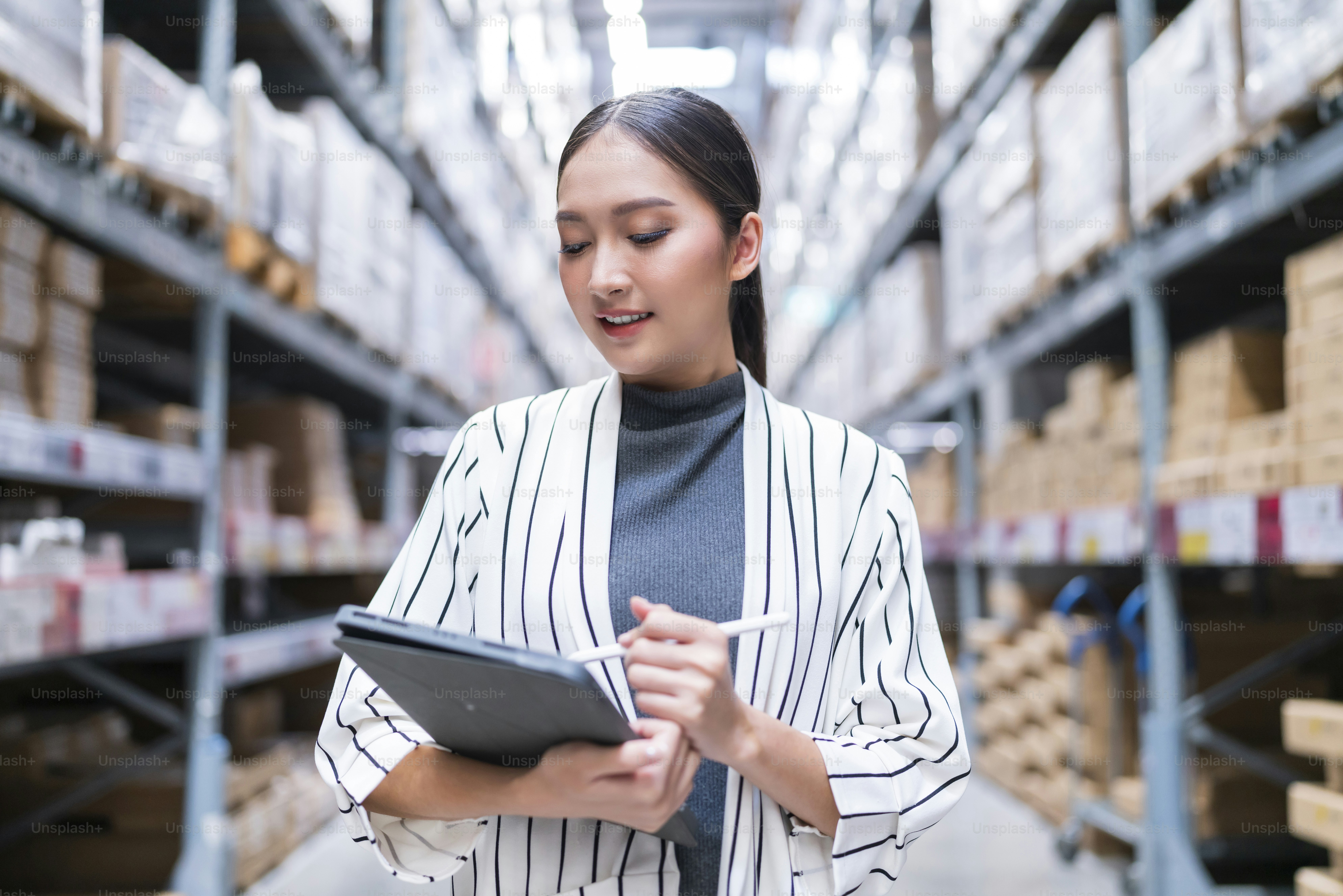 asian female business owner using digital tablet checking amount of stock product inventory on shelf at distribution warehouse factory.logistic business shipping and delivery logistic service