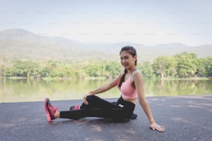 Giovane donna asiatica che beve acqua dopo l'allenamento di esercizio.