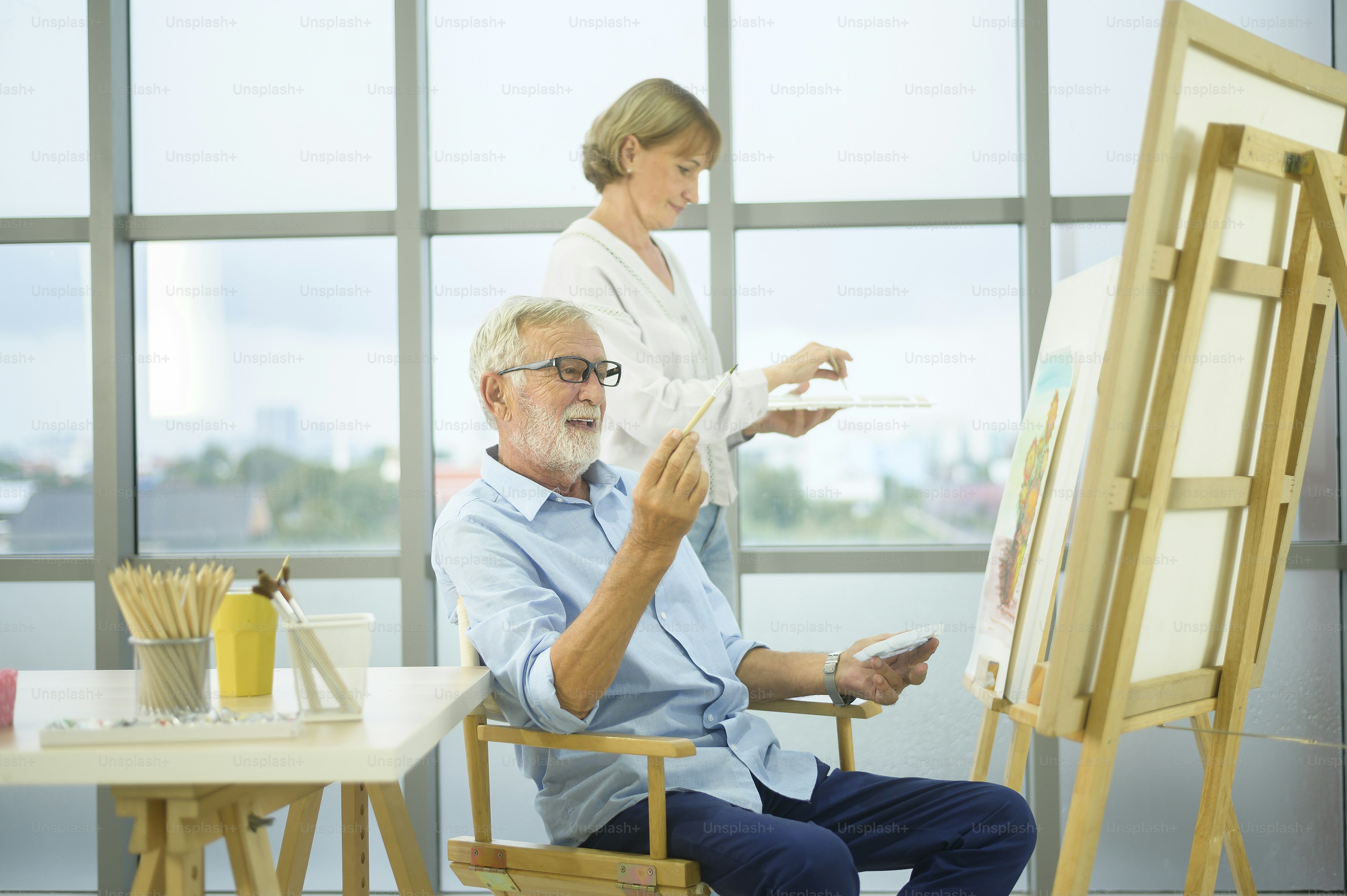 Senior caucasian couple painting and relaxing at home