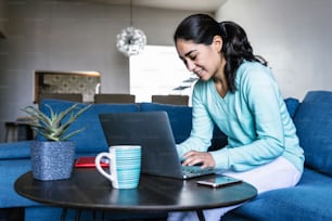Young hispanic woman working or studying with laptop at home in a home office concept in Mexico Latin America