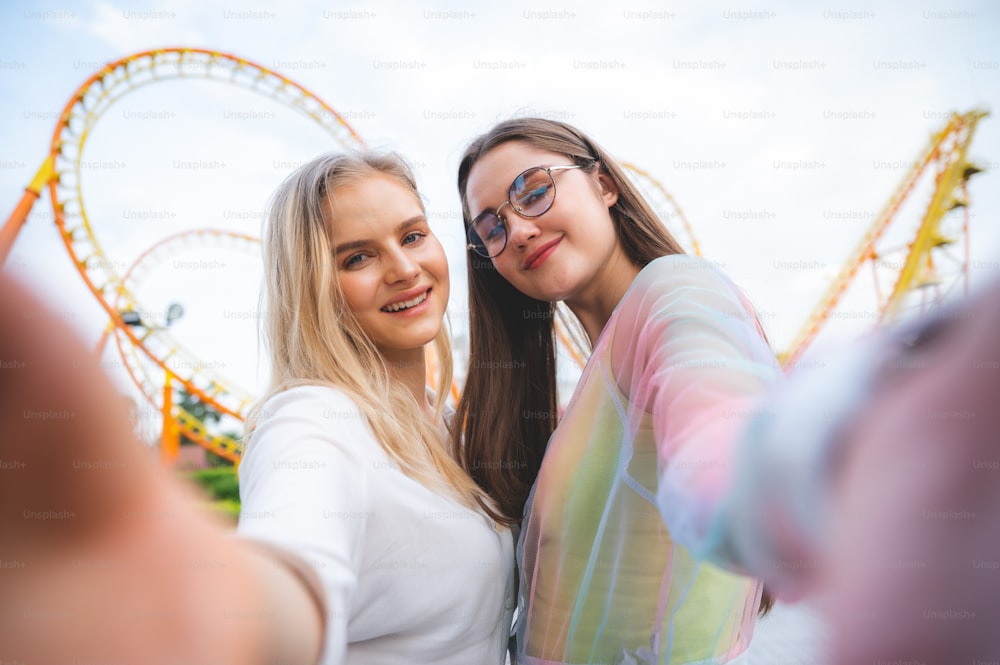 Joyful smiling girl making selfie, Outdoor portrait having fun in amusement theme park.