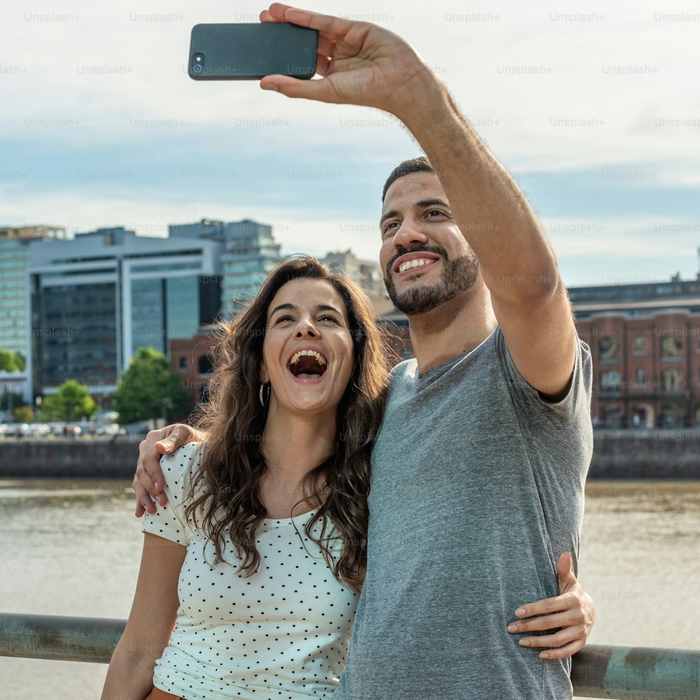 Una pareja feliz tomándose una selfie en Puerto Madero, Buenos Aires
