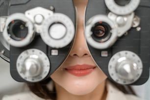 광학 센터, 안경 개념에서 안과 의사에 의해 이중 초점 검안 측정 장치를 사용하여 육안 테스트를 받는 젊은 여성 고객.