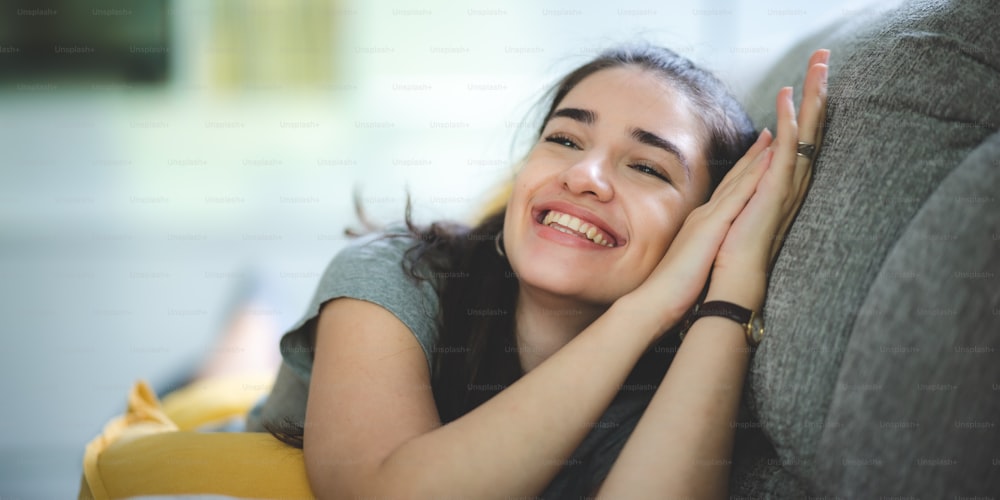 young beautiful woman person sitting in room indoor and relaxation on sofa at home, female happy living lifestyle, smiling and resting comfortable in house leisure