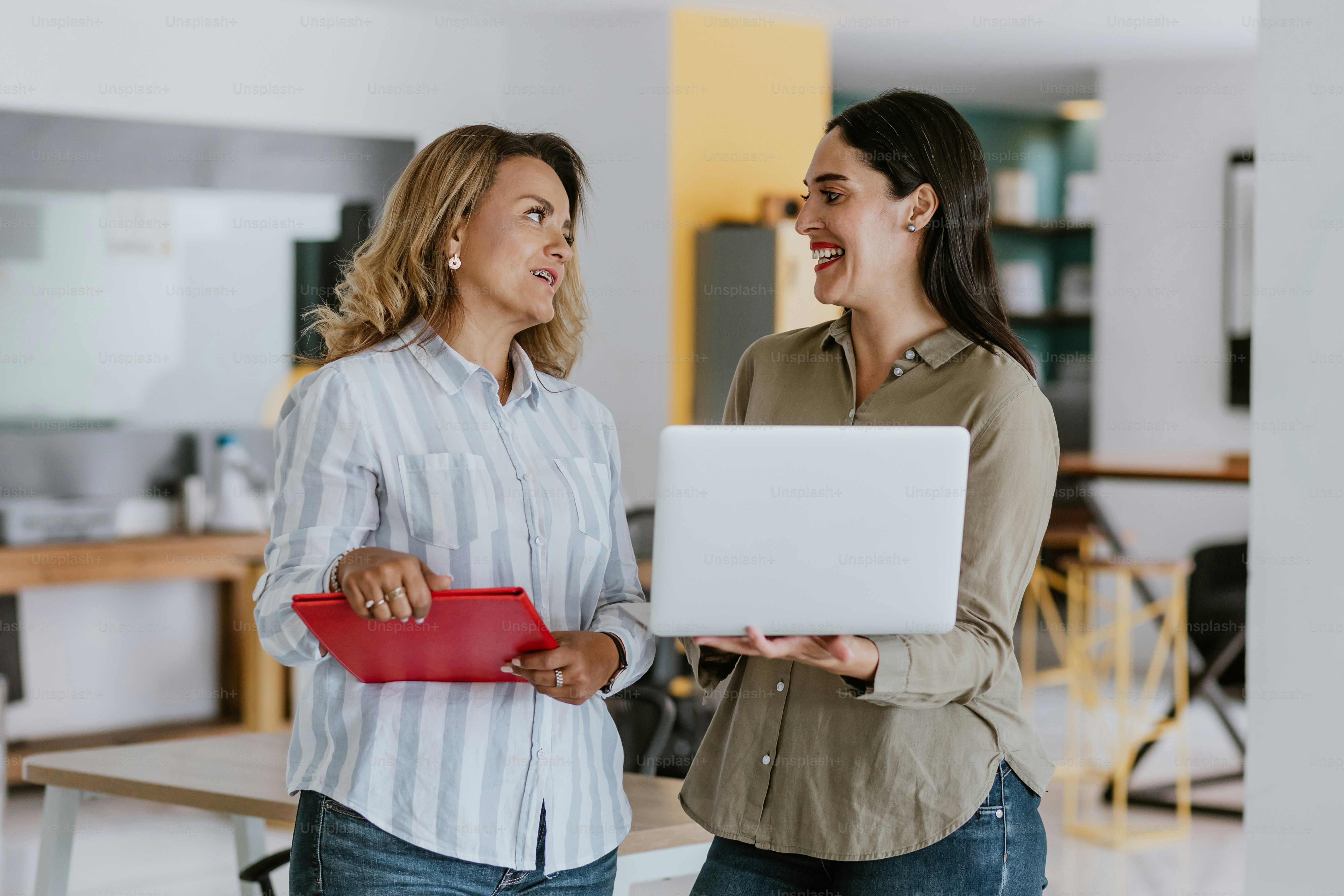 Two latin business woman middle age, talking and advising each other at ...