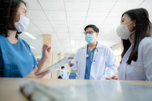 professional doctor and medicine person team have a conversation to talking in hospital about medical health care work, wearing surgical face mask