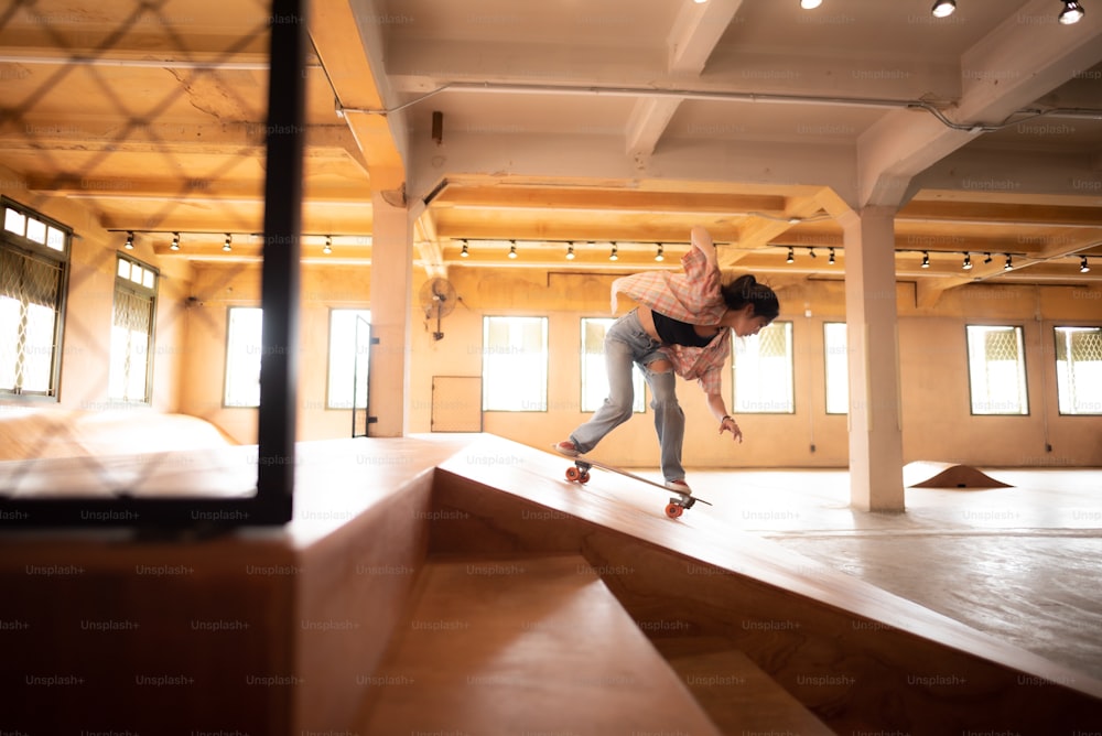 giovane donna persona in sport skate stile di vita, ragazza adolescente felice che si diverte con lo skateboard in palestra sportiva, hipster moda attività urbana alla moda alla moda