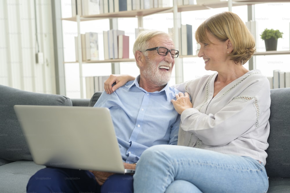 Happy Caucasian senior couple using laptop at home
