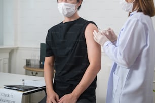 A female doctor injecting covid-19 vaccine to patient arm, covid-19 vaccination and health care concept