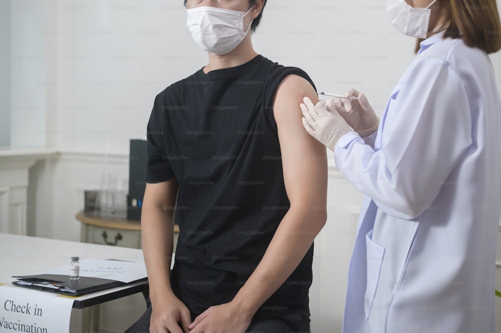 患者の腕にcovid-19ワクチンを注射する女性医師、covid-19ワクチン接種とヘルスケアのコンセプト