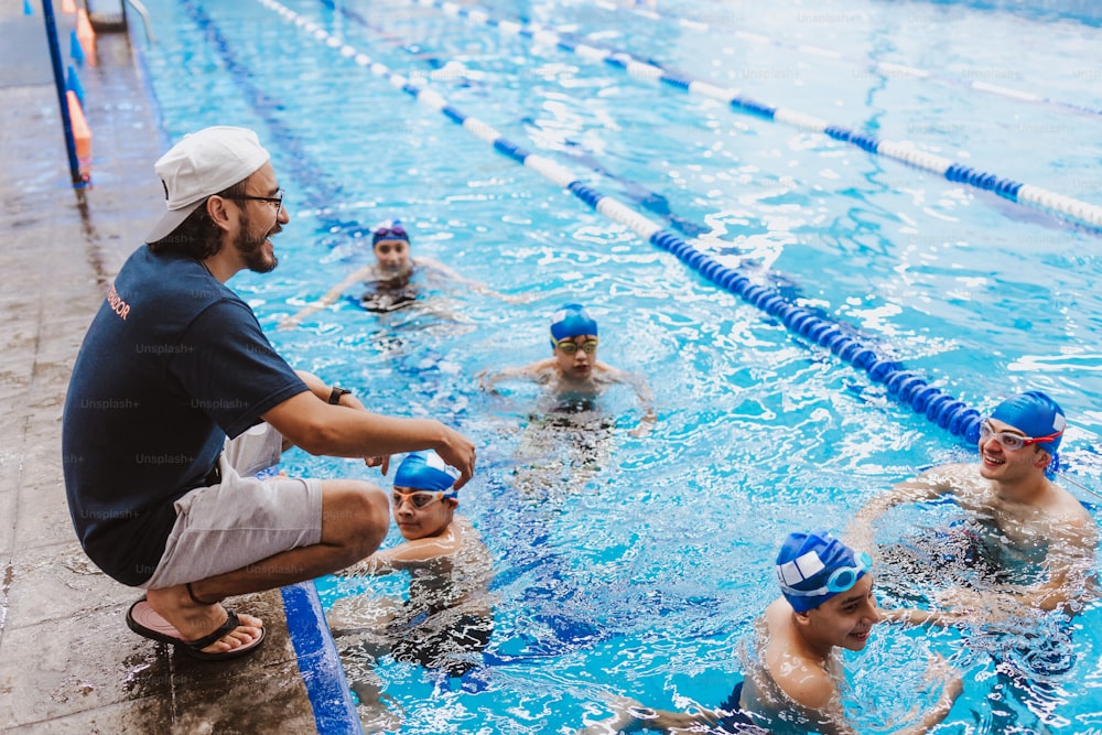 Latein Schwimmer Mann Trainer spricht einige Ratschläge für Jugendliche Schwimmer Schüler am Pool in Mexiko Lateinamerika