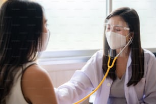 concepto de seguro de salud, joven mujer asiática médico profesional está revisando a su paciente en el hospital, consulta de atención médica de curación
