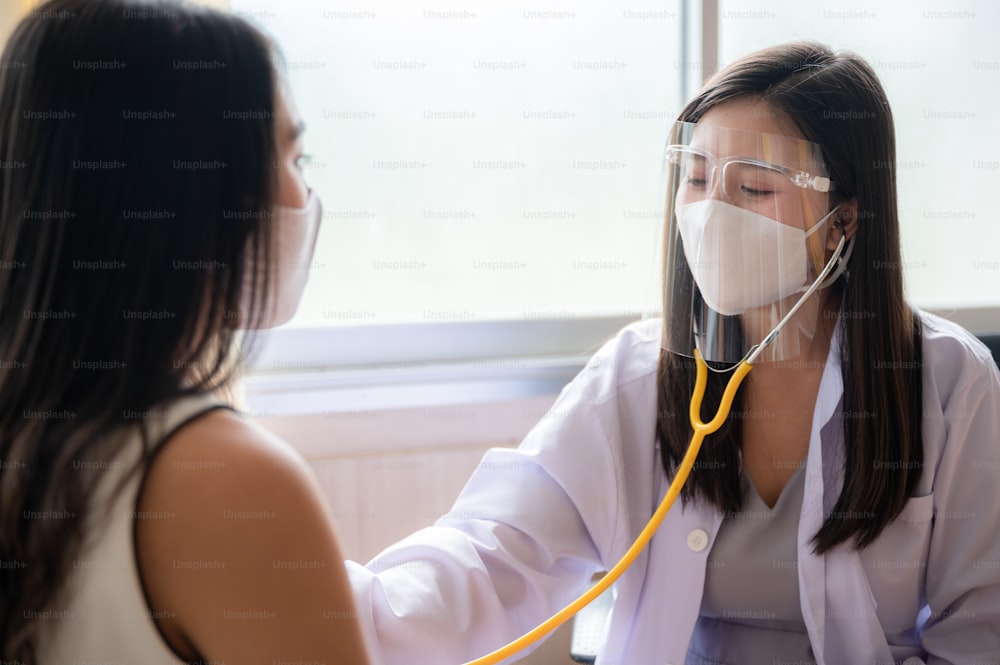 Krankenversicherungskonzept, junge asiatische Ärztin untersucht ihre Patientin im Krankenhaus, medizinische Heilungsberatung