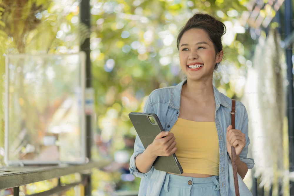 relax casual carefree smiling asian female digital nomad freelance programer hand hold laptop walking at the beach and coconut tree blue sky,new millennial lifestyle working anywhere with happiness