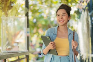 편안한 캐주얼 평온 미소 아시아 여성 디지털 유목민 프리랜서 프로그램 손 잡고 노트북은 해변과 코코넛 나무에서 산책 푸른 하늘, 새로운 밀레니엄 라이프 스타일은 어디서나 행복으로 일하는
