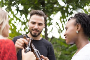 Group of friends toasting beers outdoors. Party people drinks toast celebration.