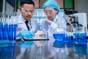 Science and medicine, scientist analyzing and dropping a sample into a glassware, experiments containing chemical liquid in laboratory on glassware, DNA structure, innovative and technology.