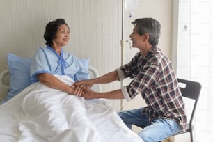 A Senior man visiting senior patient woman at hospital, health care and medical concept