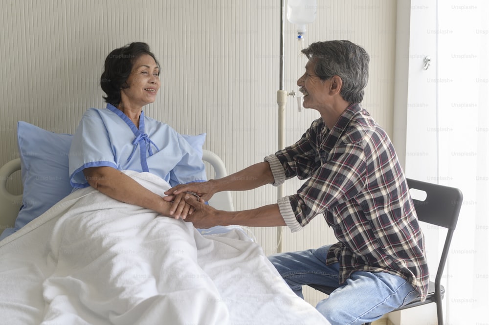 A Senior man visiting senior patient woman at hospital, health care and medical concept