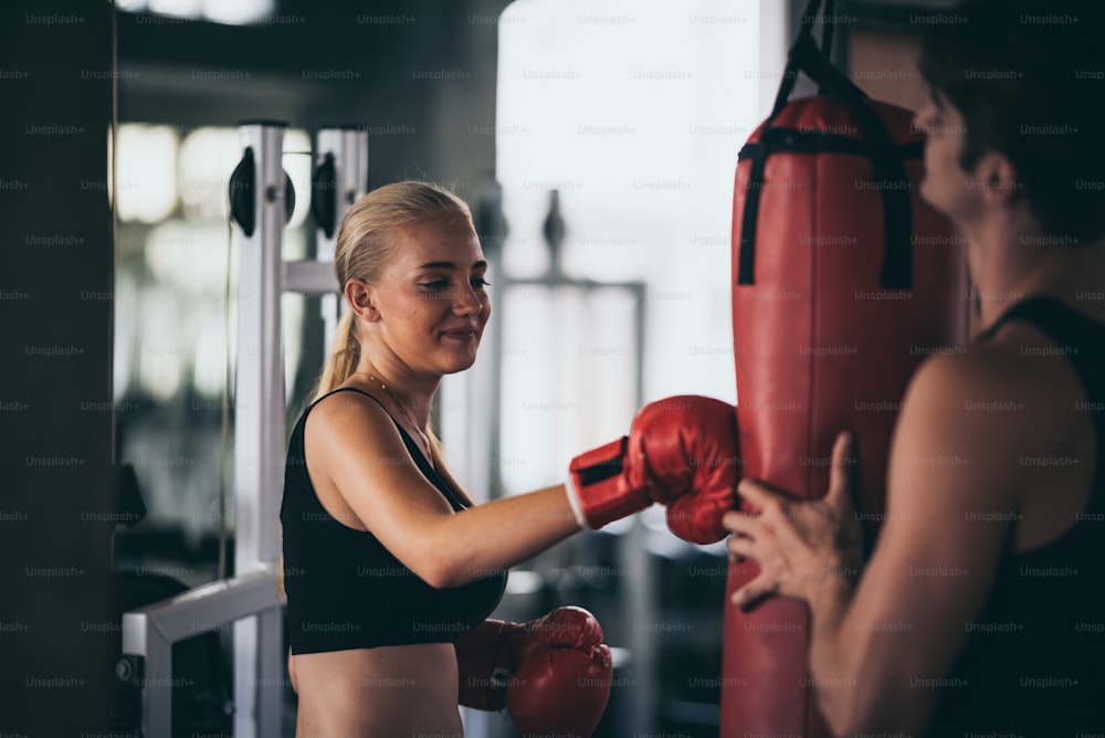 An athletic woman boxer hitting the punching bag in the gym
