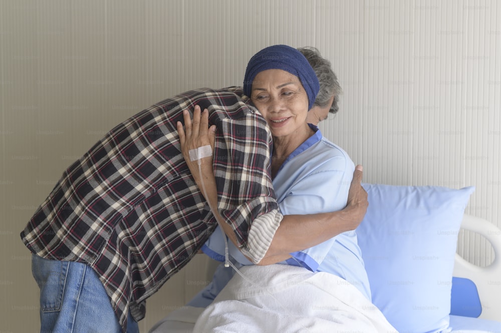 병원, 건강 관리 및 의료 개념에서 머리 스카프를 착용 한 암 환자 여성을 방문하는 노인 남성