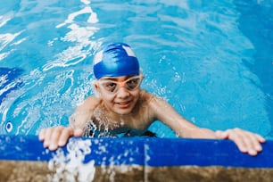 niño latino niño nadador con gorra y gafas en un entrenamiento de natación en la piscina en México América Latina