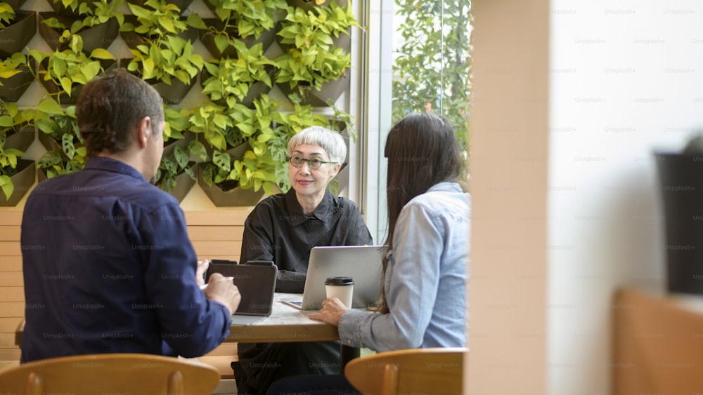 Group of business people brainstorming in coffee shop