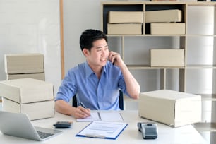 Young male business owner working at home, Receive product orders via phone