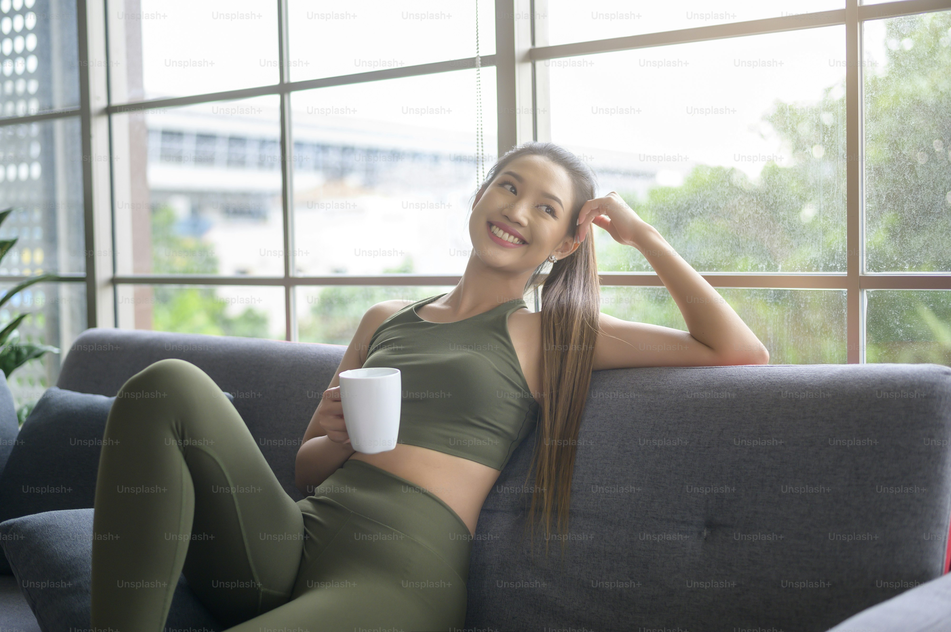 Young fitness woman in sportswear having a cup of coffee after exercising at home, Healthy and Lifestyles.