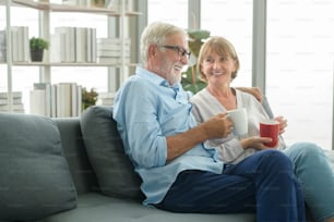 幸せな白人の先輩夫婦は、家でコーヒーを飲んでいて、リラックスしてヘルスケアのコンセプトを持っています。