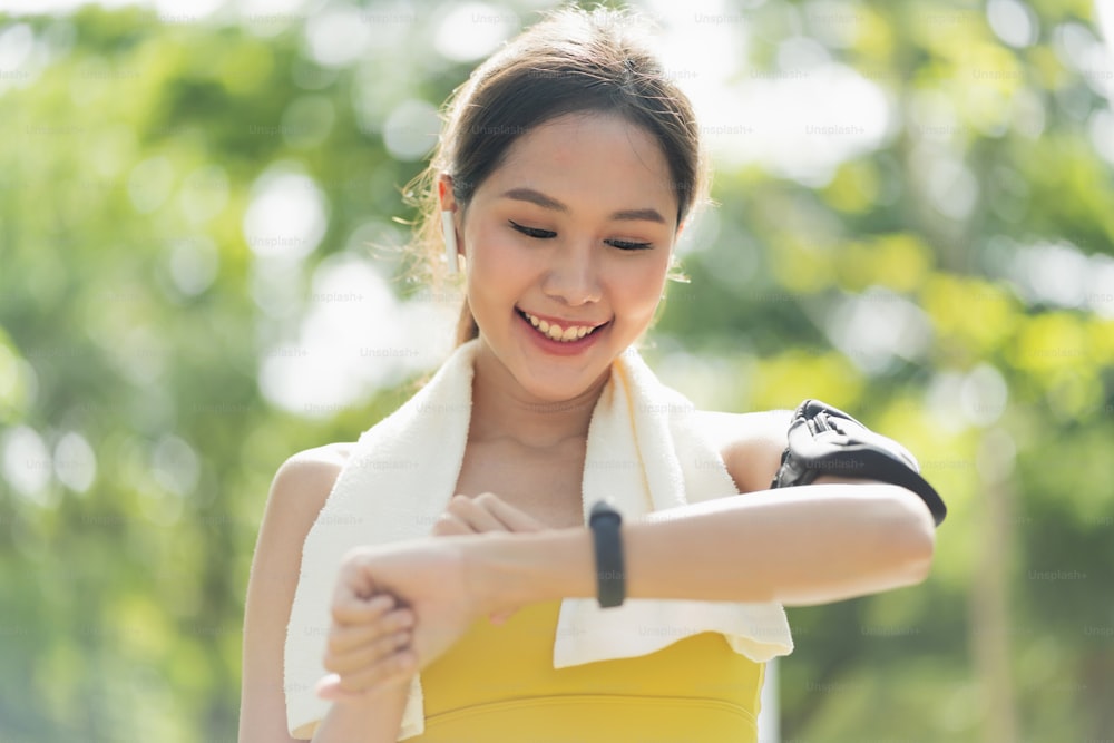 asian Fitness woman setting up smart watch before running training during morning workout,female checking heartrate and pulse from smart watch monitor after running fininsh healthy lifestyle concept