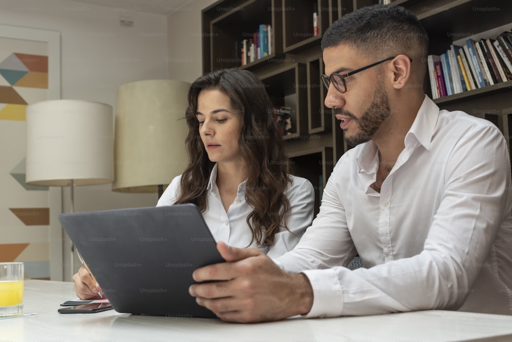Una pareja de negocios trabajando juntos con una computadora portátil.
