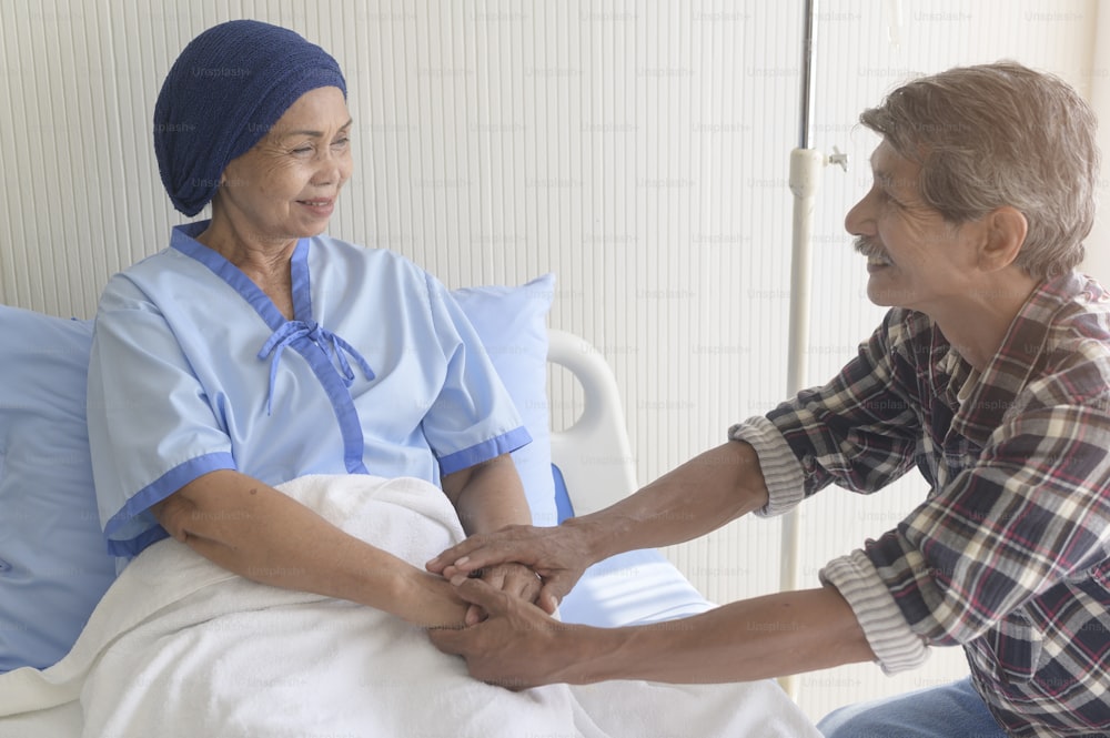 Un homme âgé rendant visite à une patiente atteinte d’un cancer portant un foulard à l’hôpital, aux soins de santé et au concept médical