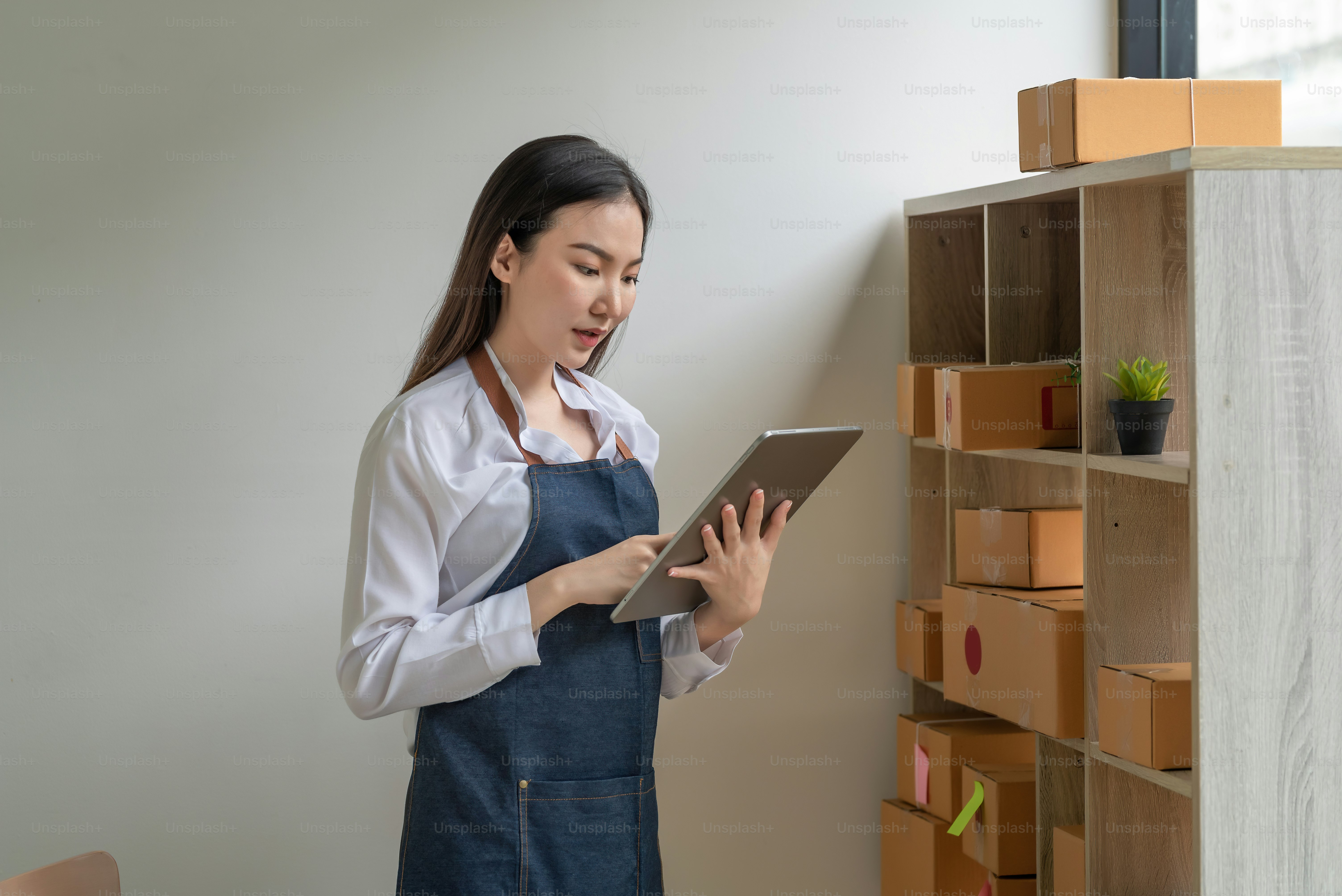 Beautiful Asian businesswoman is pleased to deliver online products to customers. Working at home concept.