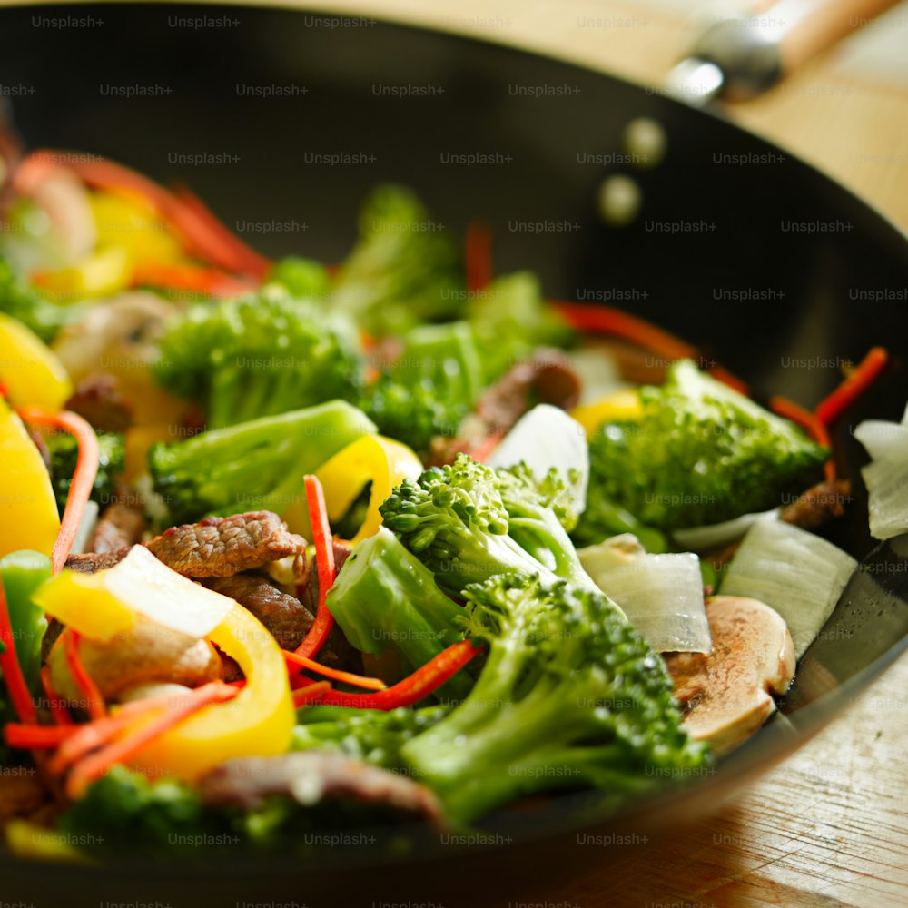 Rindfleisch-Wok-Pfanne mit Gemüse wie Brocoli, gelber Paprika, Pilzen, Zwiebeln und Karotten.  (Anmerkung - selektiver Fokus)