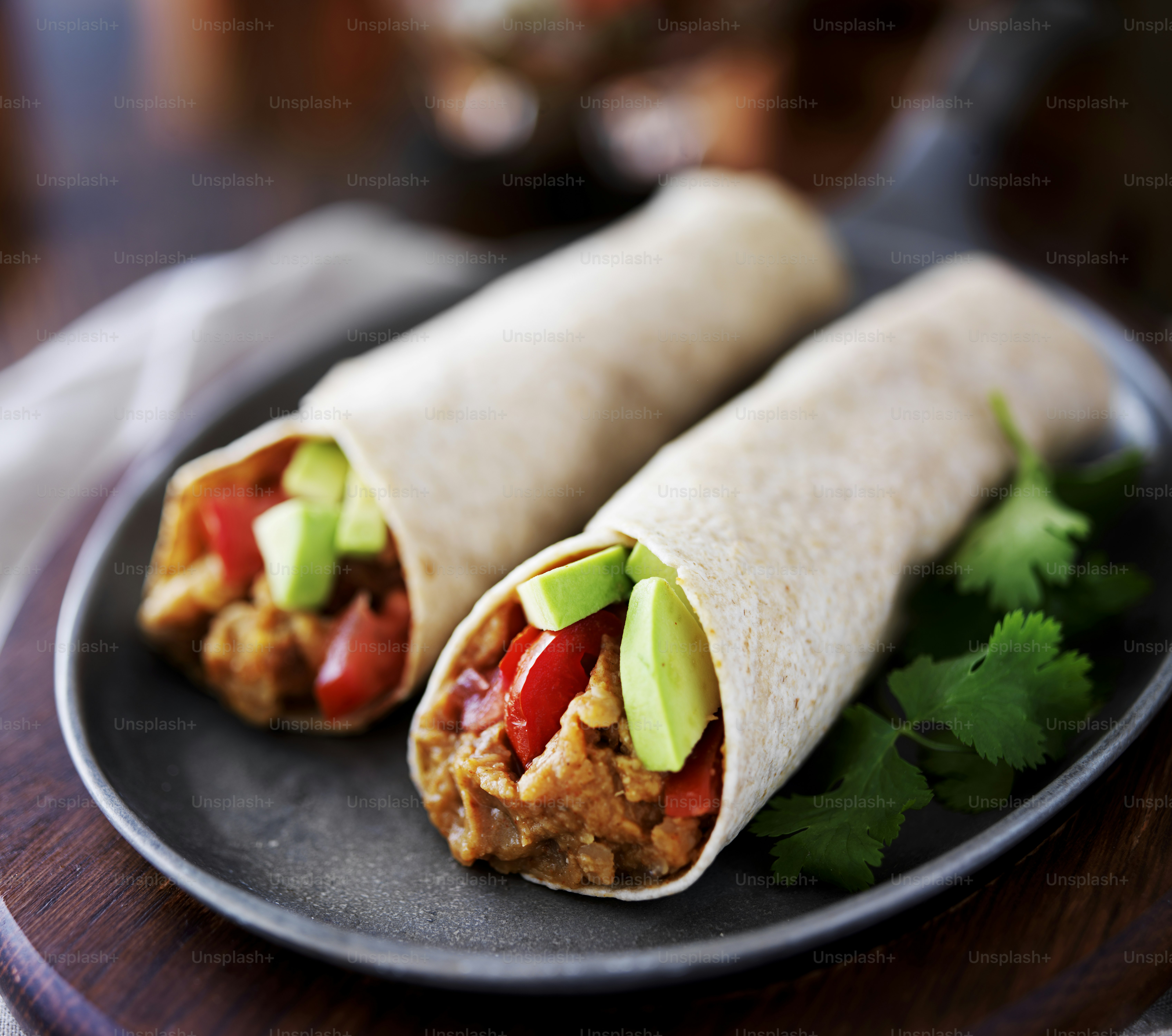 Dos burritos veganos con aguacate, tomate y lentejas